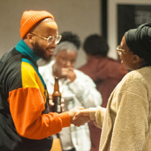 Three young adults at the happy hour reception in conversation.